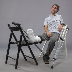 man with crutches sitting