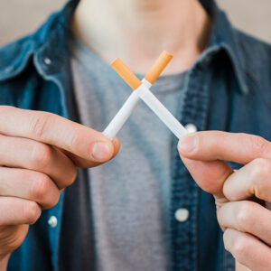 man making x with cigarettes